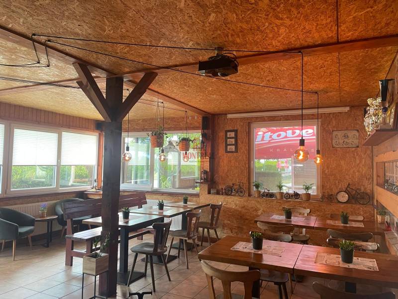 Interior of dining spaces with tables, wooden paneling, and decorative lights.