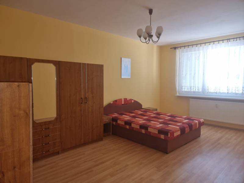 Bedroom in a 2-room apartment with a bed, wardrobe, and yellow walls.