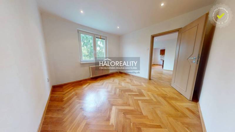 A room in a 3-room apartment with a patterned floor and open doors.