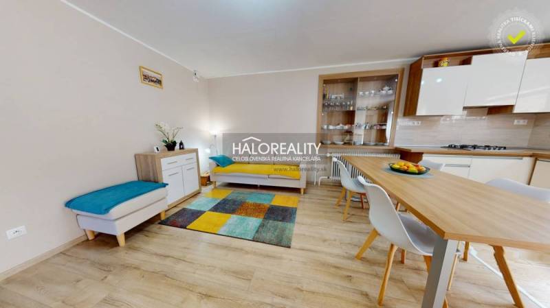 Modern interior of a family house with a dining table and a colorful carpet.