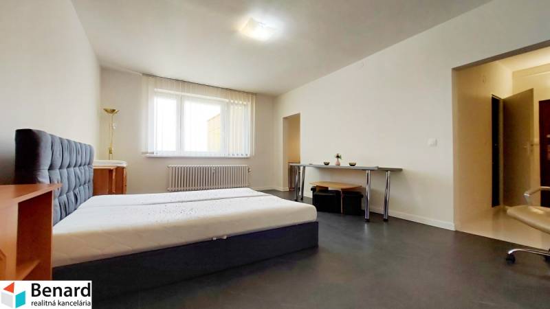 1-bedroom apartment with a bedroom, a desk, and white walls, part of comfortable living.