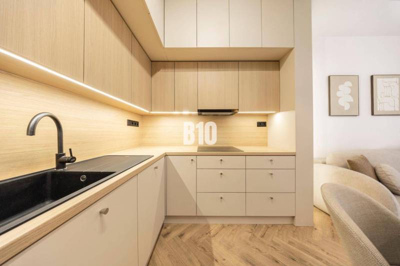 The kitchen on Benediktiho Street in a 3-room apartment, with a minimalist wooden design.