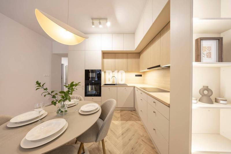 The kitchen in a 3-room apartment on Benediktiho Street, with a table and modern lighting.