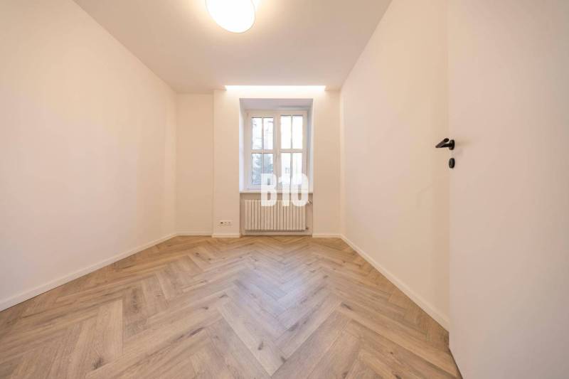 A bright room with a parquet floor and a window in a 3-room apartment on Benediktiho Street.