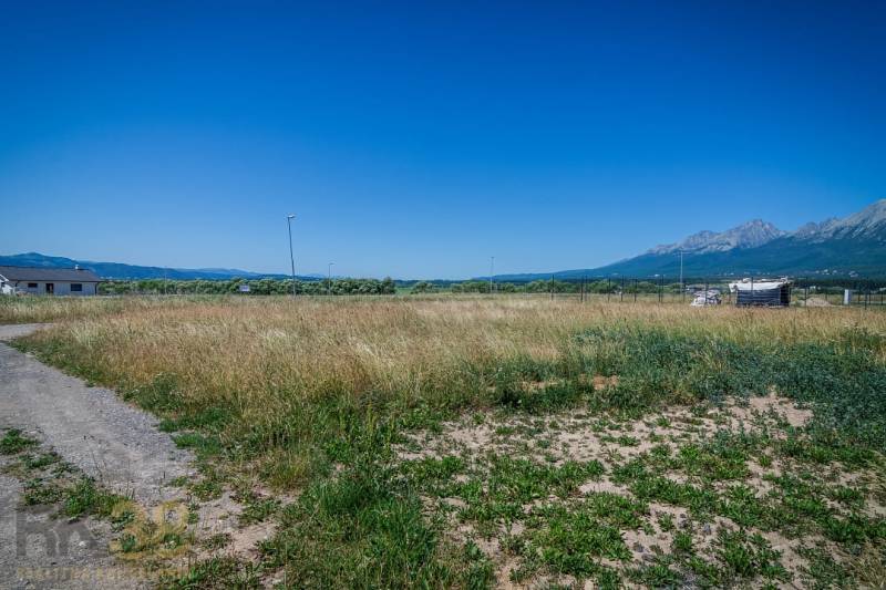 Residential plots in Mlynica surrounded by mountains and blue skies.