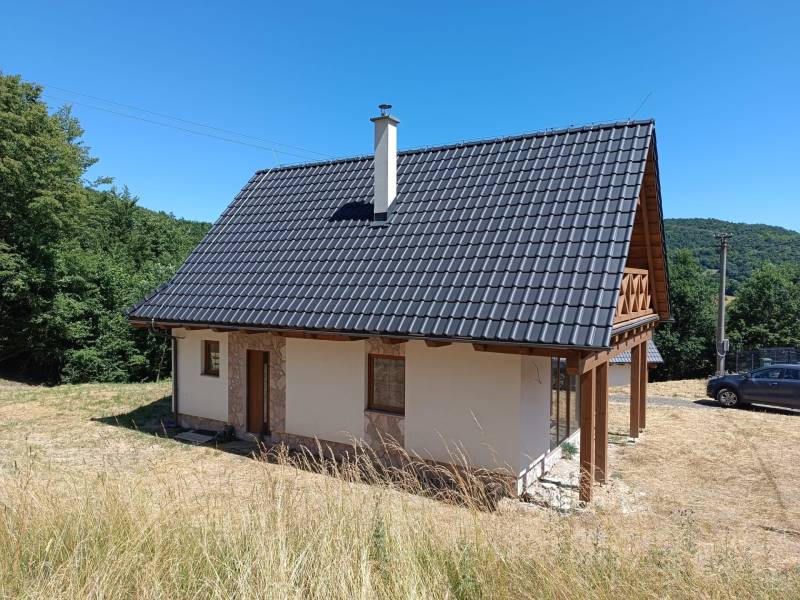 A cottage in Horné Hámre with a wooden roof and a veranda, surrounded by nature.