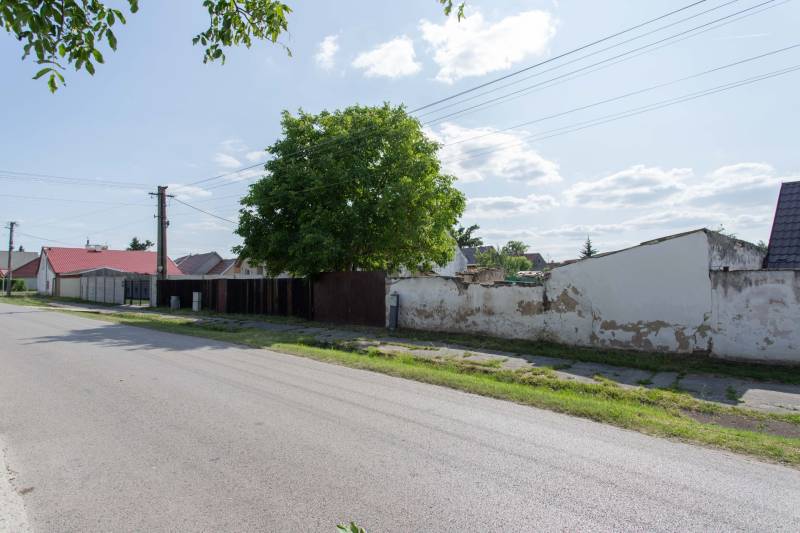 Športová Street in Gajary with residential plots, next to the road and trees.