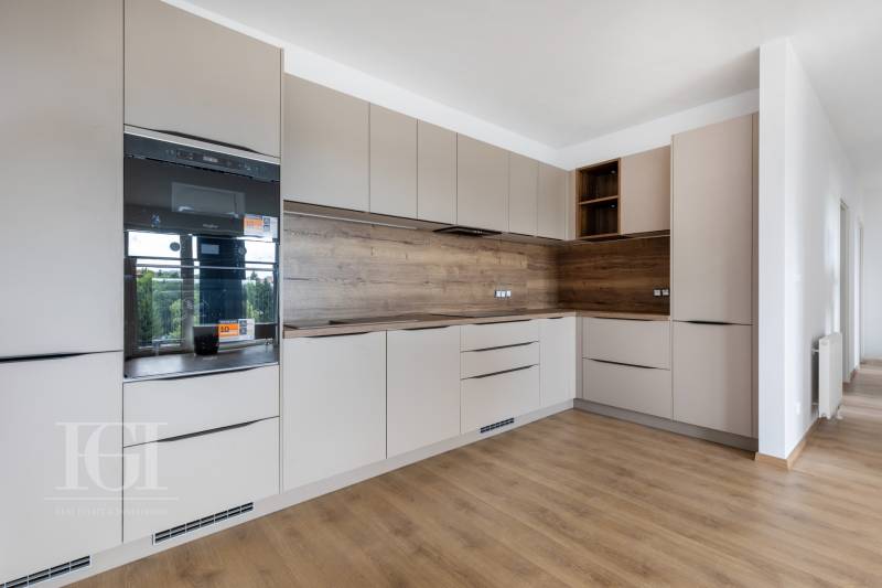 A kitchen in a 3-room apartment with wooden flooring and built-in appliances.