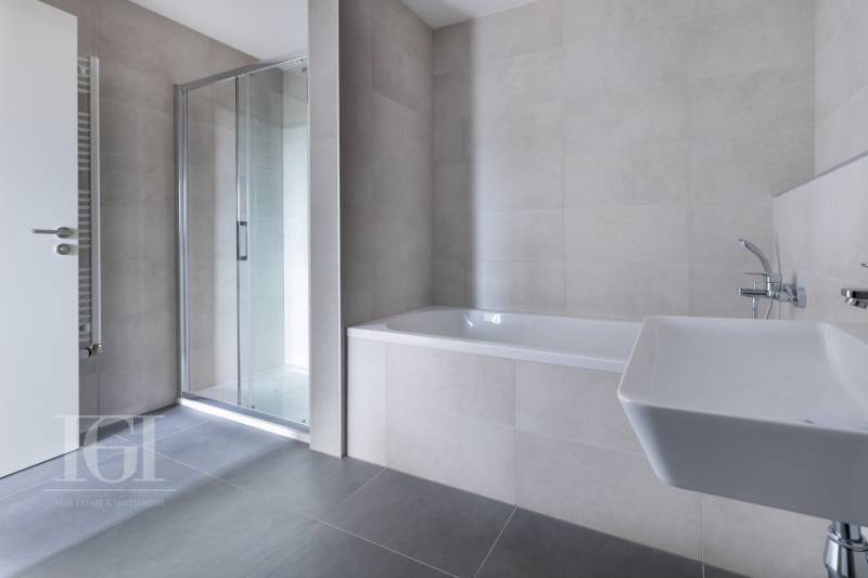 A bathroom in a 3-room apartment with a bathtub, shower, and sink.