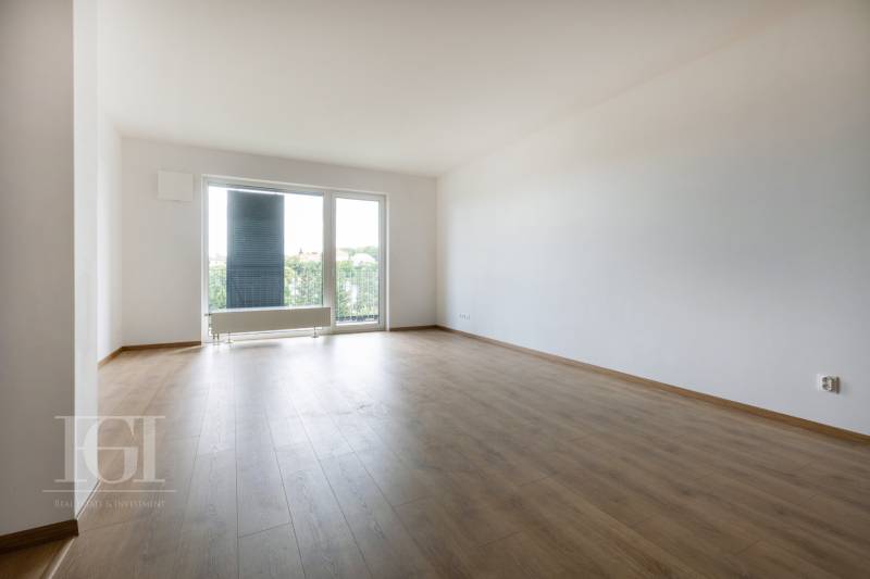 Spacious living room in a 3-room apartment with a view through a large window.