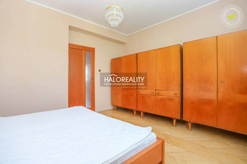 A bedroom in a 3-room apartment with a built-in wardrobe and wooden furniture.