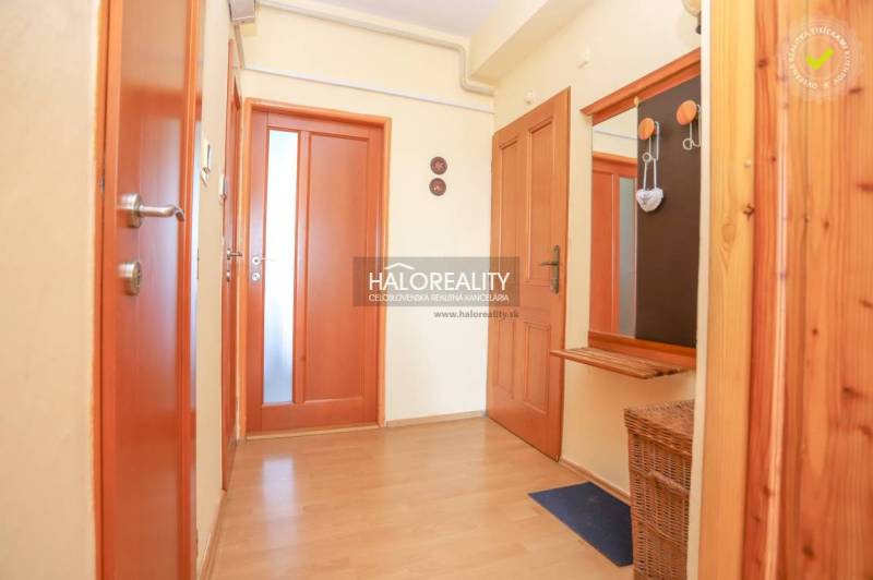 A hallway in a 3-room apartment with wooden flooring and doors.