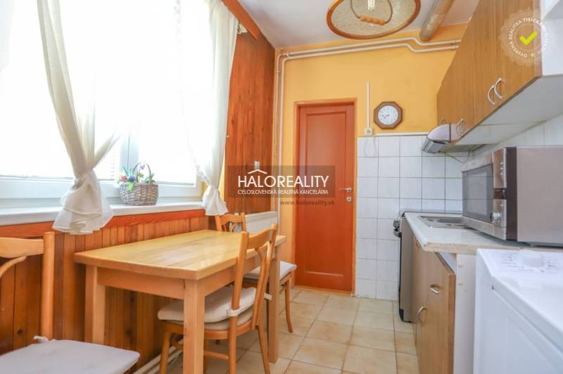 A kitchen in a 3-room apartment with a wooden table and chairs.