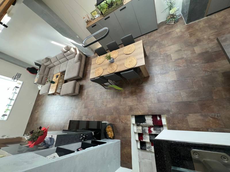 Interior of a family house with a spacious living area, sofa, and dining table.