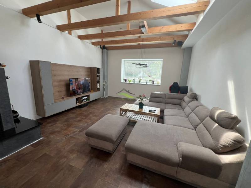Living room in a family house with a comfortable sofa and wooden beams.