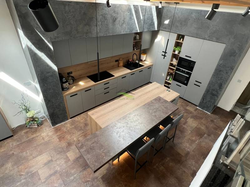 A kitchen in a family house with an island, gray cabinets, and wooden accents.