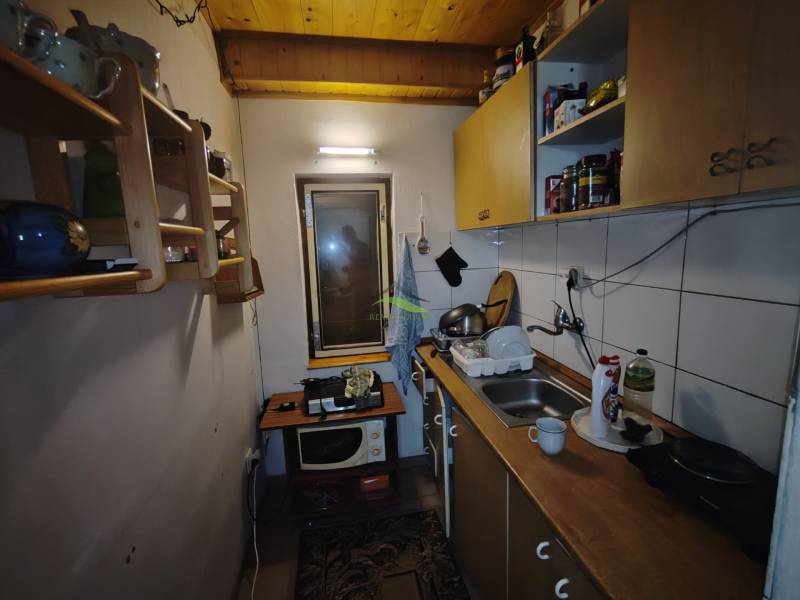 Cozy kitchen in a cabin with a wooden ceiling and standard equipment.