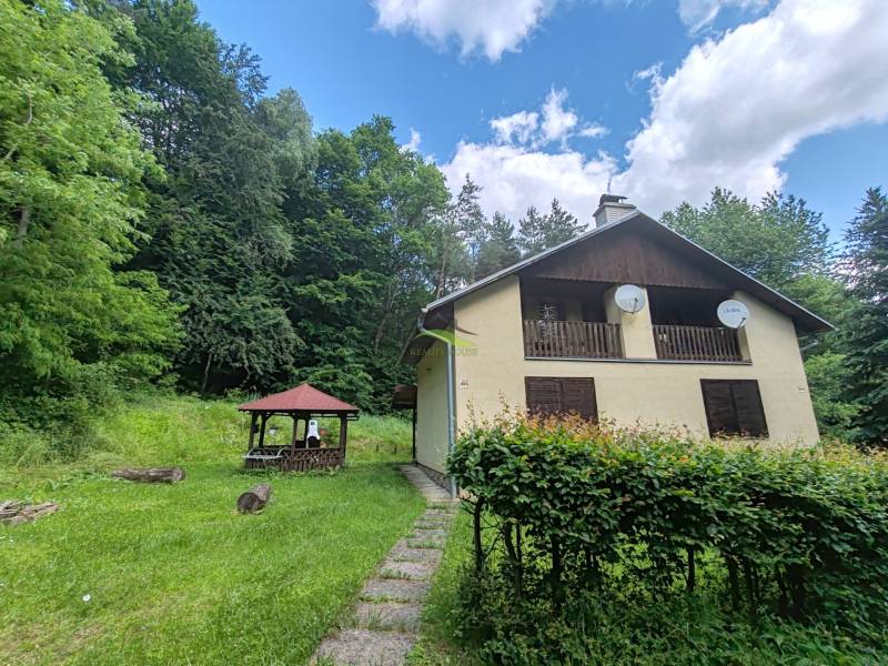 The cottage on Dobra in Kvakovce, surrounded by greenery, near the forest and the gazebo.