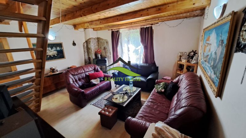 Living room in a cabin with wood-patterned flooring and comfortable leather sofas.