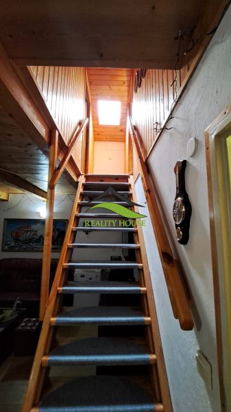 A staircase in a cottage with wooden decor and decorative elements on the walls.