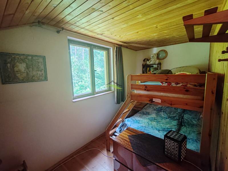Bunk bed in the interior of a cabin with a wooden ceiling.