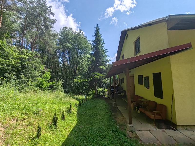 The cottage on Dobra in Kvakovce is surrounded by greenery and a forest environment.