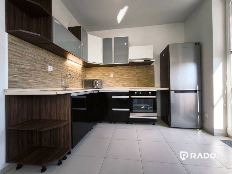 A kitchen in a 2-room apartment with modern equipment and a corner cabinet set.