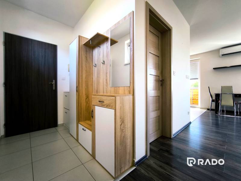 Hallway in a 2-room apartment with furniture and a view into the dining room.