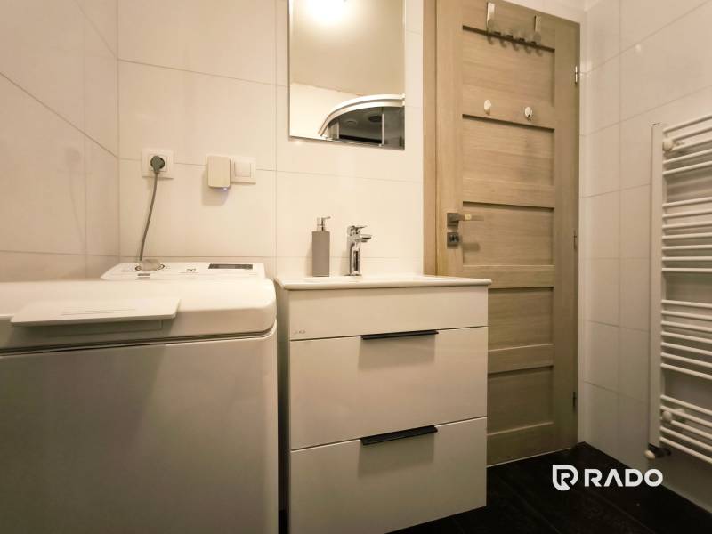 Bathroom with a washing machine, wardrobe, and mirror in a 2-room apartment.