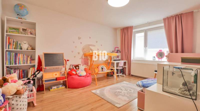 Children's room in a family house with toys, books, a blackboard, and an aquarium.