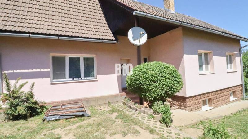 A family house in Podhradie with a satellite dish and landscaped outdoor area.