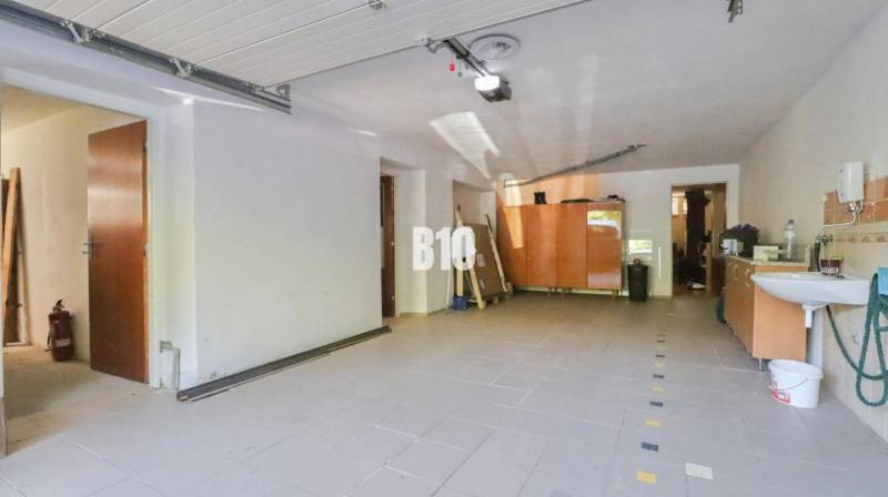A spacious garage in a family house with a sink and storage spaces.