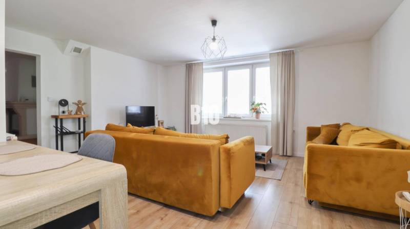 Living room in a family house with yellow sofas and a dining table.