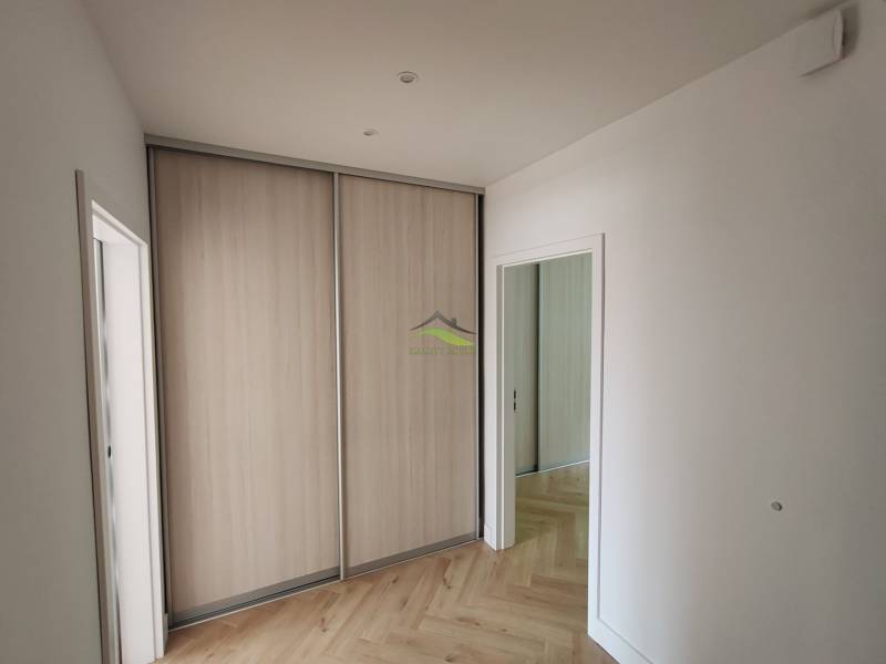 Interior of a 2-room apartment with a built-in wardrobe and light parquet flooring.
