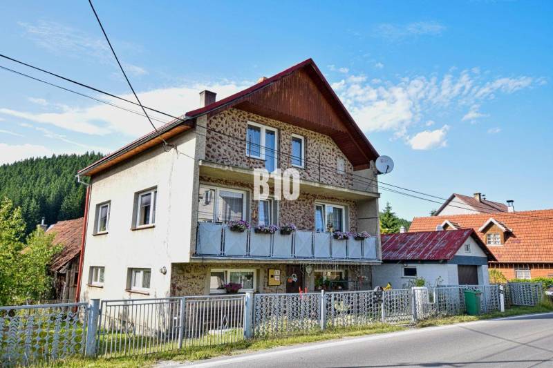 A family house in Turzovka with flowers on the balcony and a satellite dish.