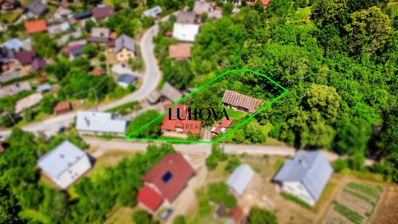 Aerial view of a family house in Púchov surrounded by green gardens and a street.