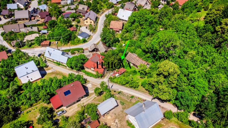Aerial view of family houses and surroundings in Púchov, surrounded by greenery and roads.
