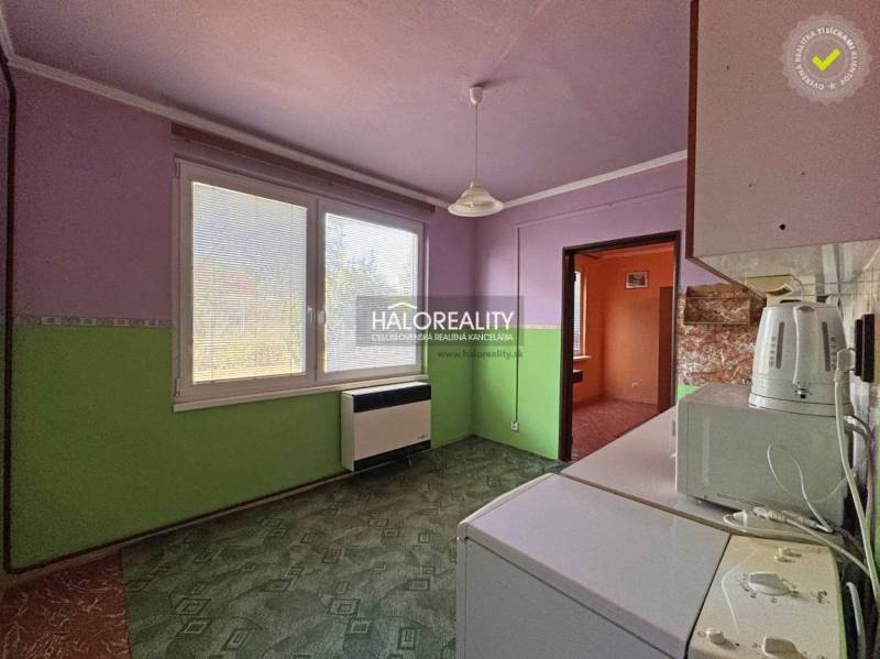 Kitchen in a studio apartment with a view, light wall, furnishings.