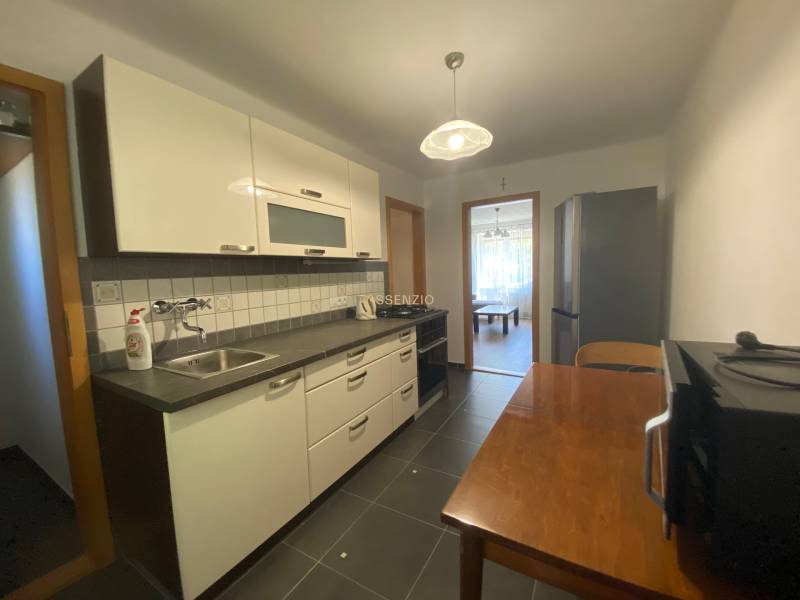 Kitchen in a 2-room apartment with a kitchenette, dining table, and appliances.