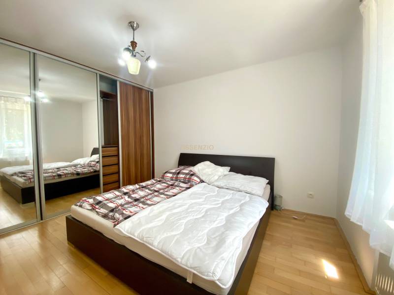 Bedroom with a bed and built-in wardrobe in a 2-room apartment.