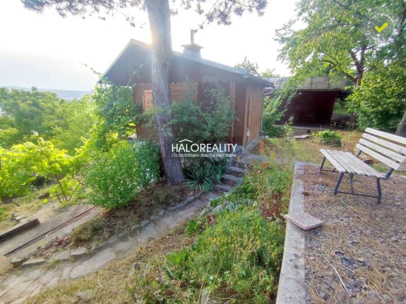 Gardens in Zvolen with a cottage, bench, and abundant greenery allowing for relaxation in nature.
