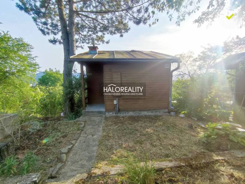 A wooden cabin in the gardens of Zvolen surrounded by trees and nature.