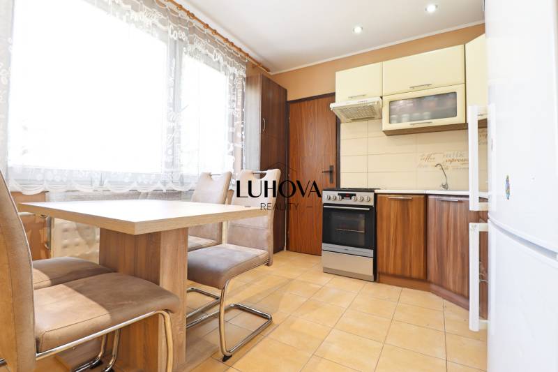 Kitchen in a 3-room apartment with a dining table and chairs, bright atmosphere.