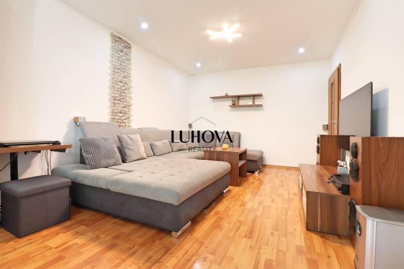 Living room in a 3-room apartment with a comfortable sofa and wooden flooring.