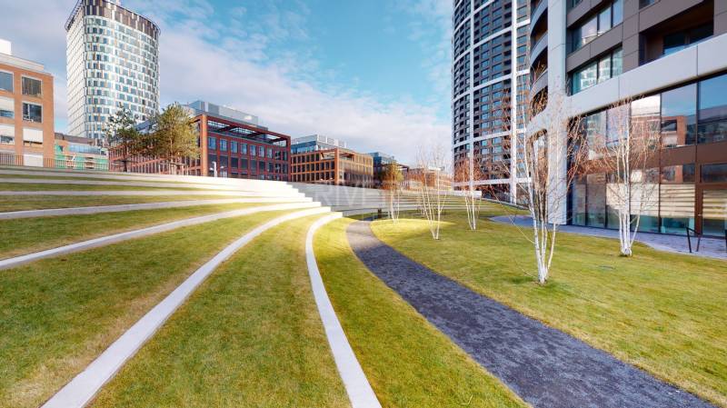 An amphitheater with a lawn, surrounded by modern buildings on Čulenova Street, appears peaceful.