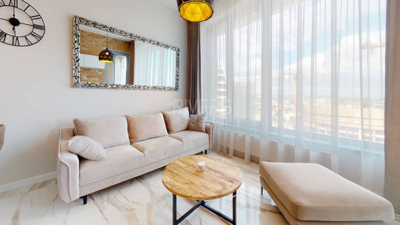 A bright living space with a comfortable sofa and a large mirror in a 2-room apartment.