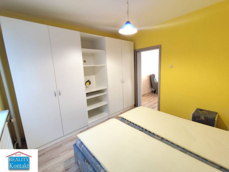 Yellow bedroom with a large white wardrobe in a 3-room apartment.