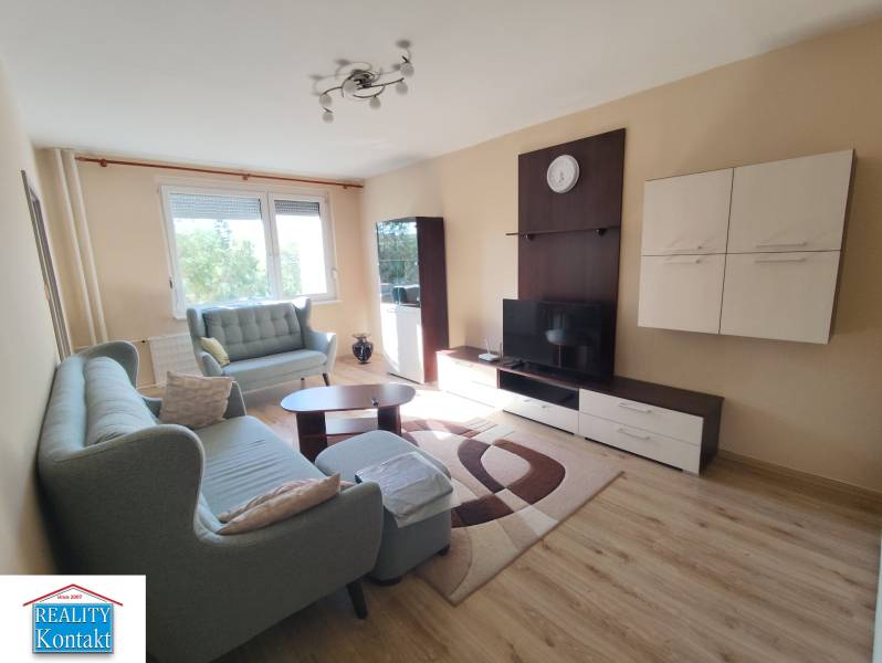 Living room in a 3-room apartment with a sofa, TV furniture, and a window in the background.