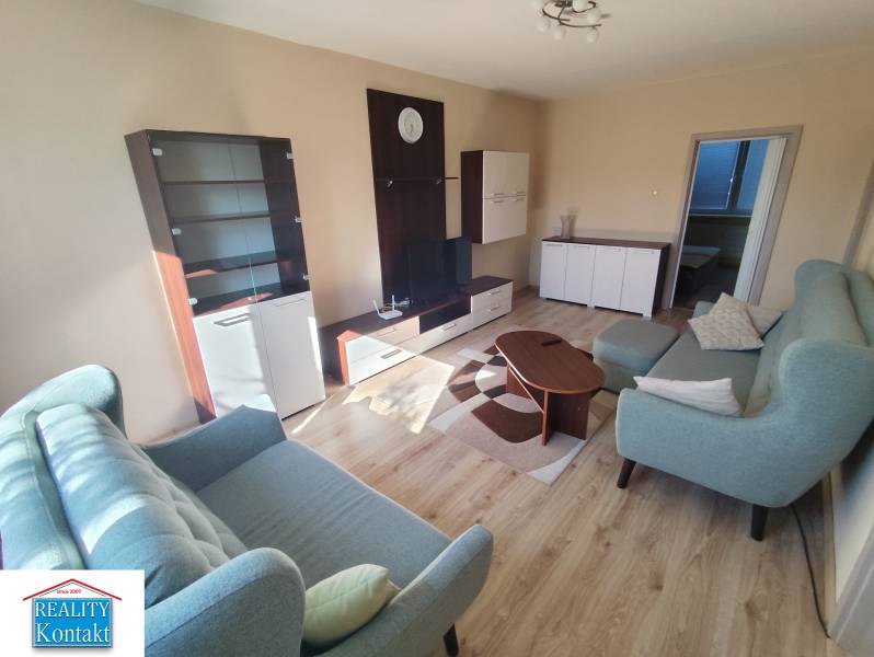 Living room in a 3-room apartment with a sofa, coffee table, and display cabinet.