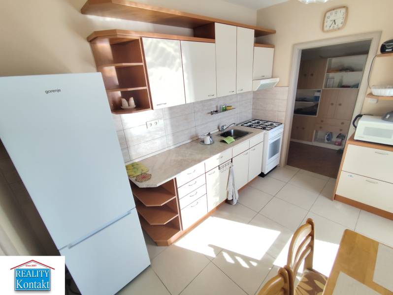 The kitchen of a 3-room apartment with white appliances and a kitchen unit.